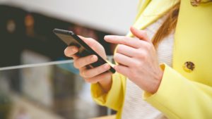 Female uses smart phone in shopping center